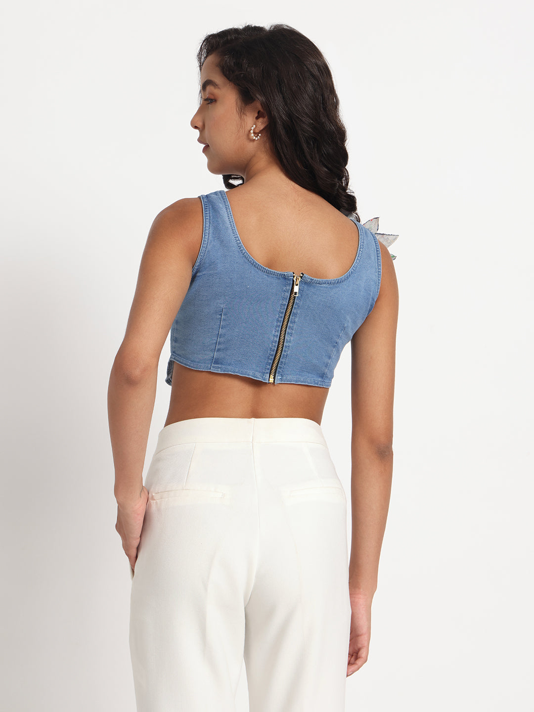 Back view of woman wearing Gotamoda blue jeans top with zipper and white pants
