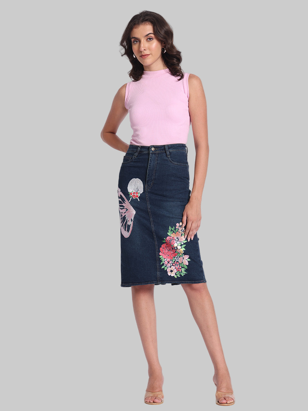 Gotamoda dark blue Denim Skirt with floral and butterfly embroidery worn by woman in pink sleeveless top