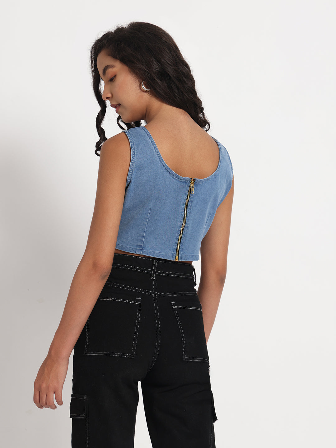 Gotamoda jeans crop top in light blue denim with back zipper, worn by model with black pants