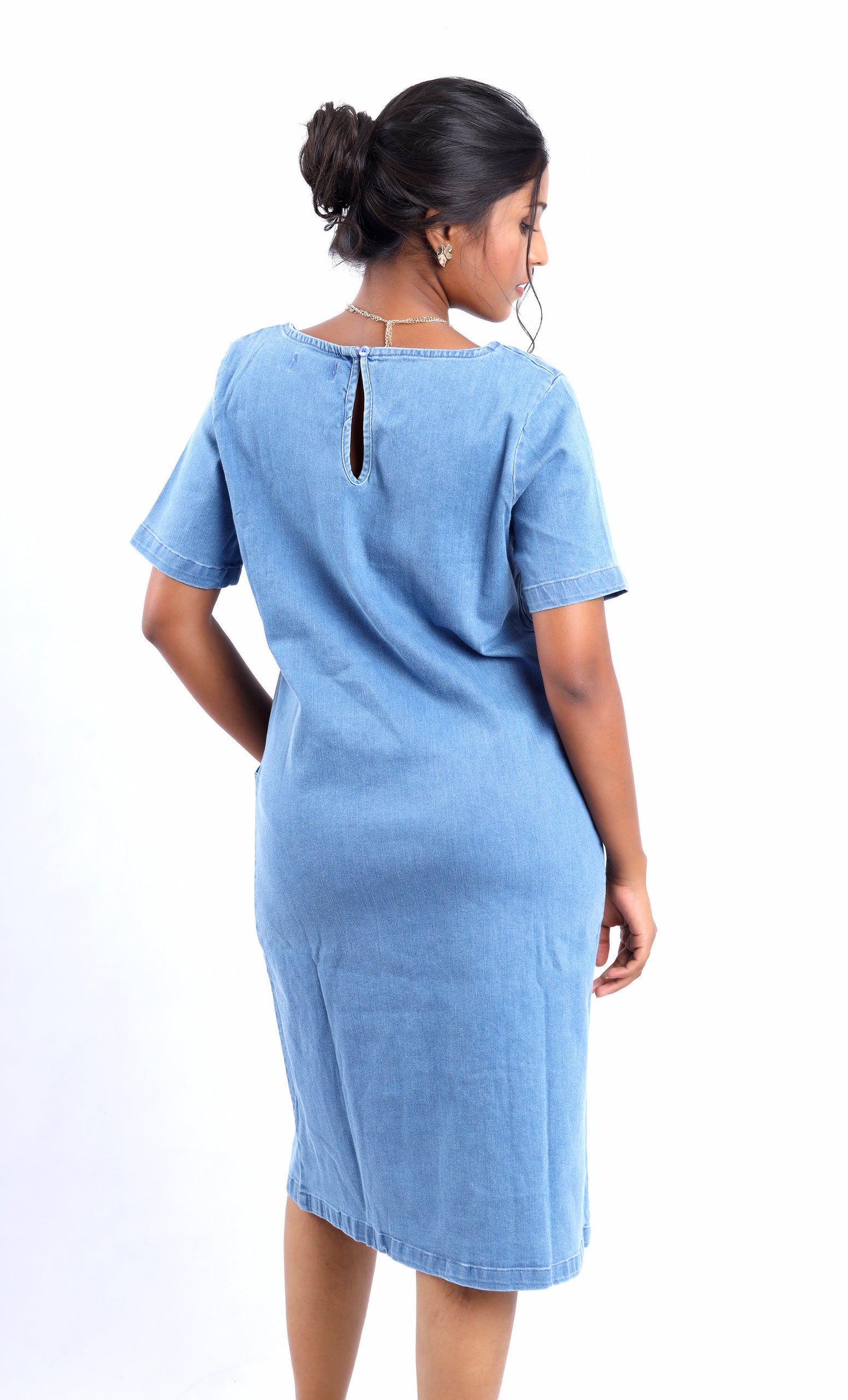 Back view of a woman wearing a midi denim dress with sleeves in light blue by Gotamoda