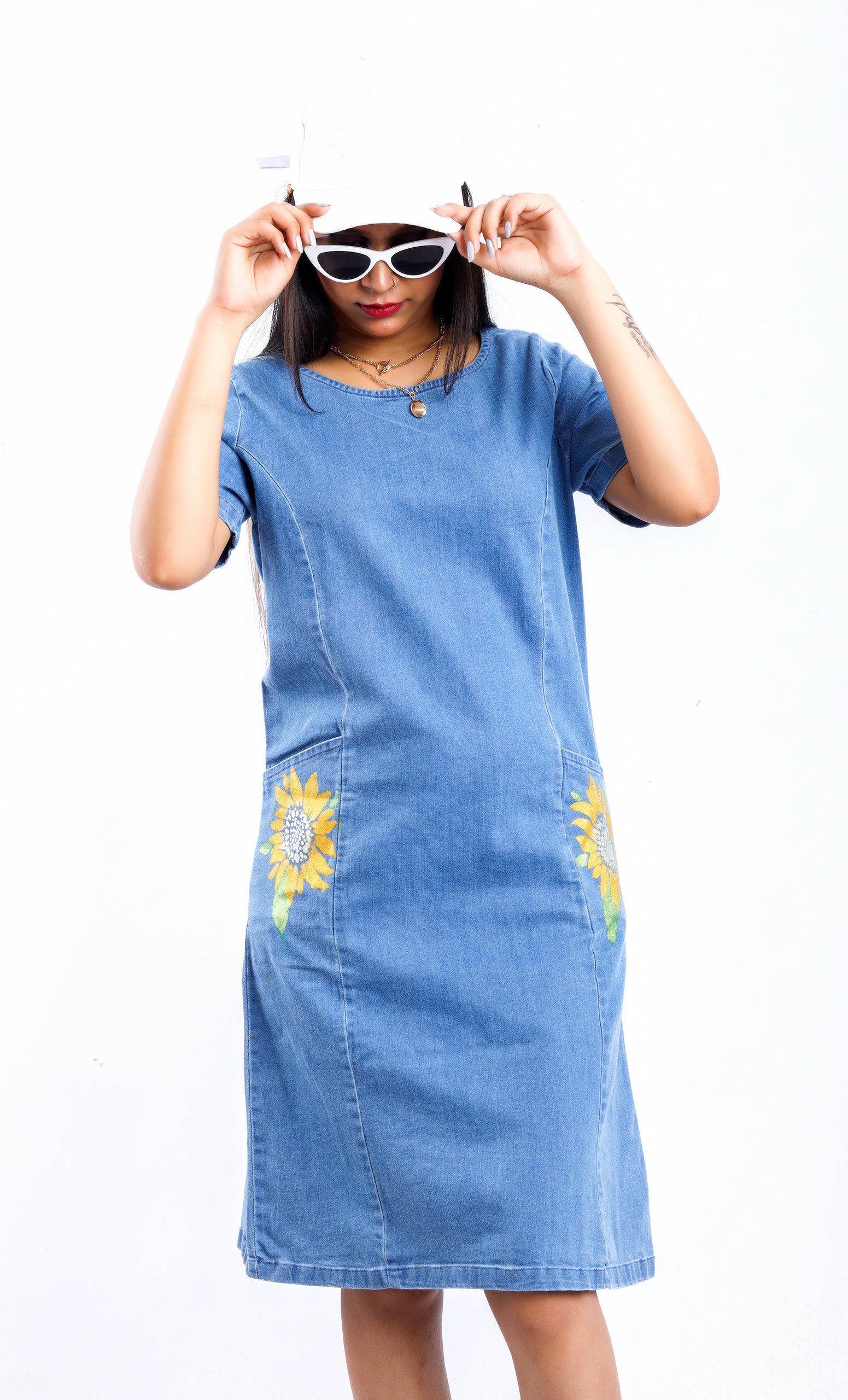 Woman wearing Gotamoda Sunflower Radiance Denim Dress with yellow sunflower embroidery on pockets
