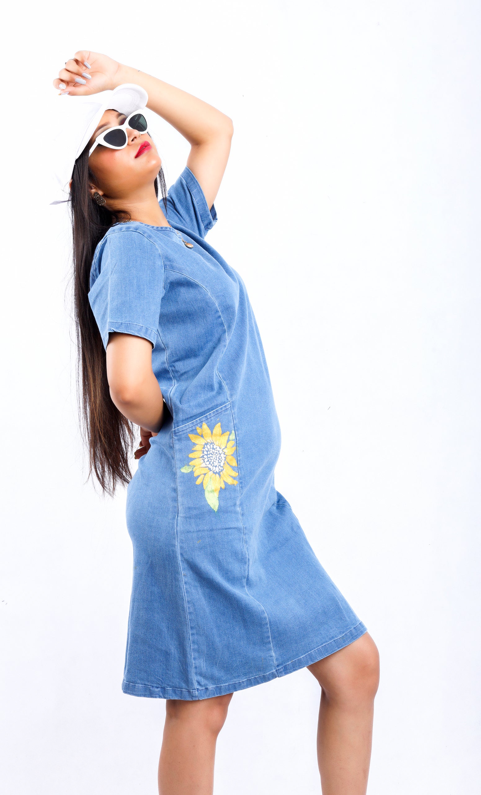 Woman wearing Gotamoda Sunflower Radiance Denim Dress with sunflower embroidery on side and white sunglasses