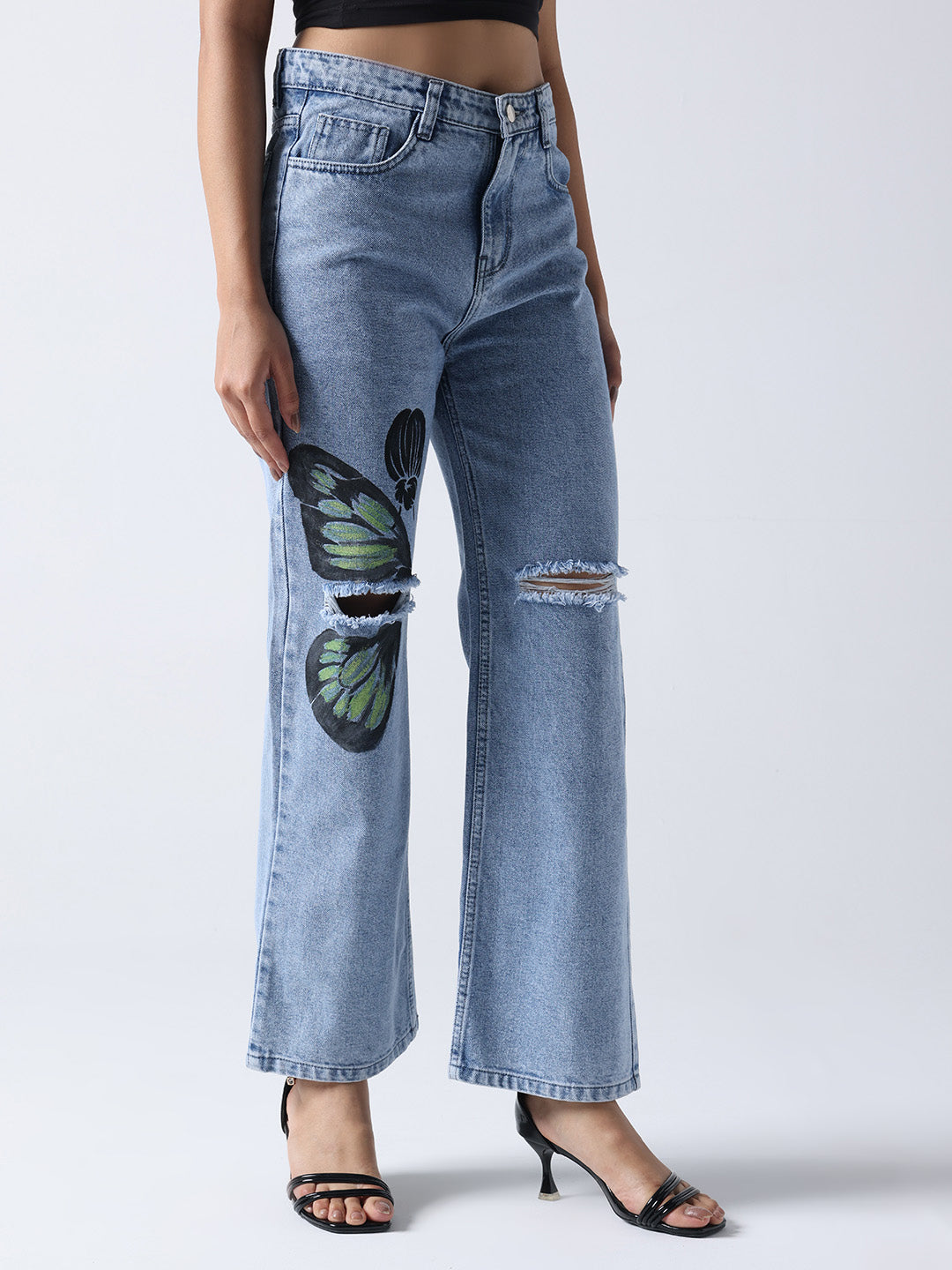 Gotamoda hand painted jeans with butterfly design and ripped knee detail on model