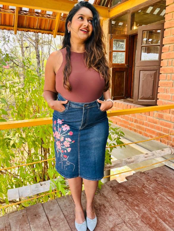Curvy woman wearing a denim skirt with floral embroidery styled confidently outdoors denim skirts for curvy women