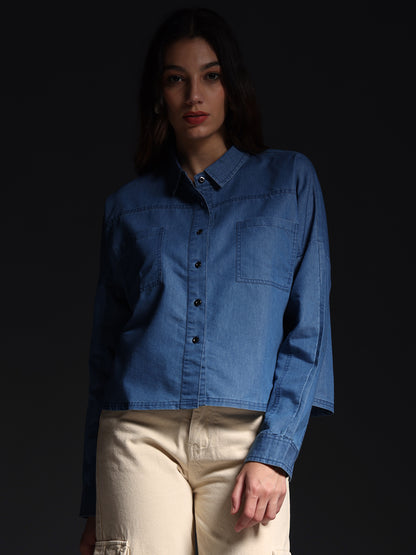 Gotamoda autumn petals shirt in light blue denim worn by a woman with beige pants