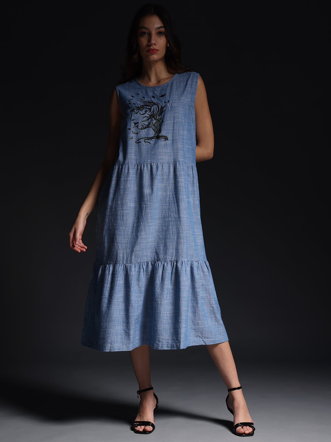 Gotamoda Sleeveless Maxi Dress in blue with tree embroidery, tiered design, and ankle-strap heels