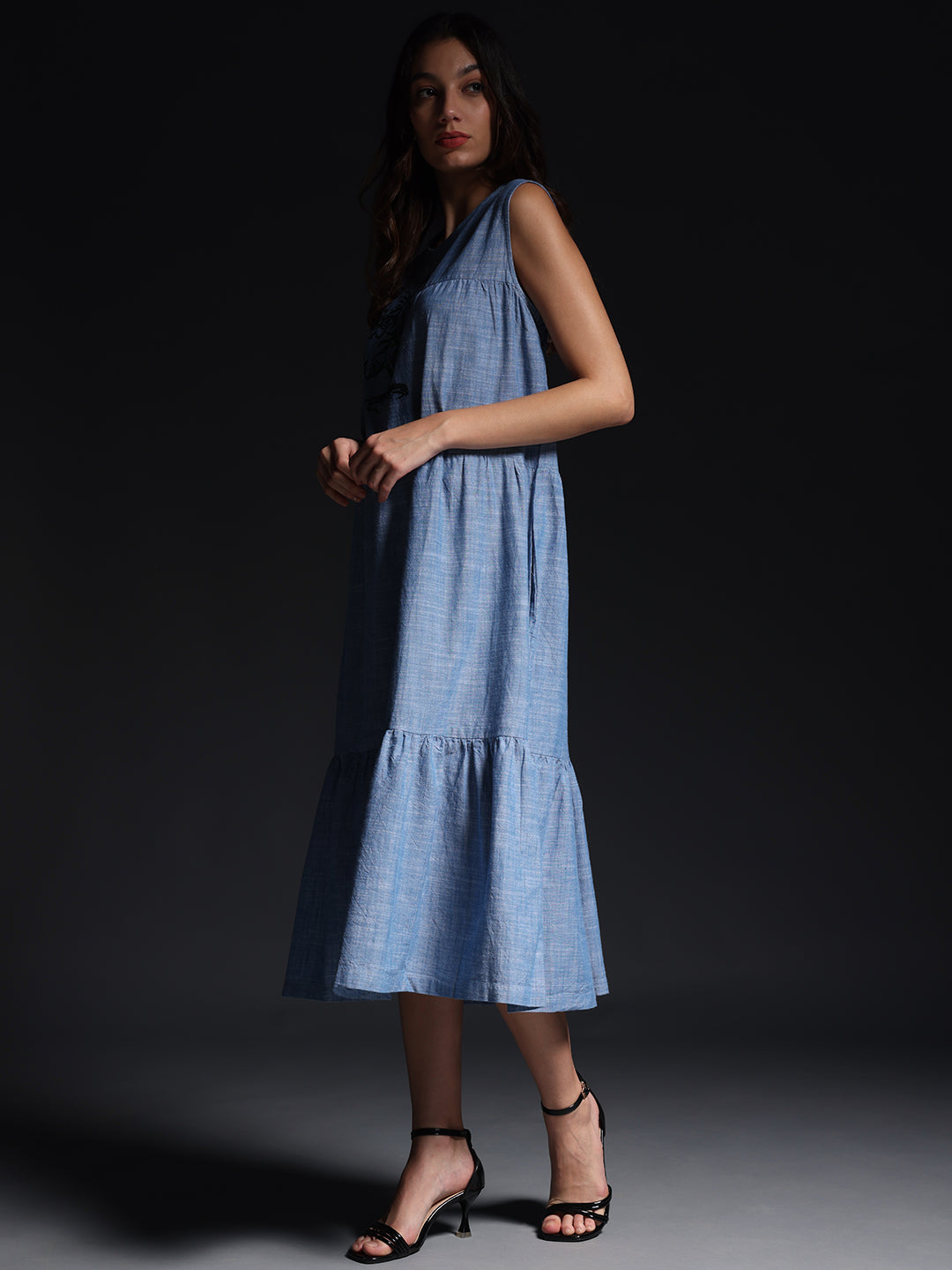 Gotamoda sleeveless maxi dress in light blue with button front and tiered hem worn by model