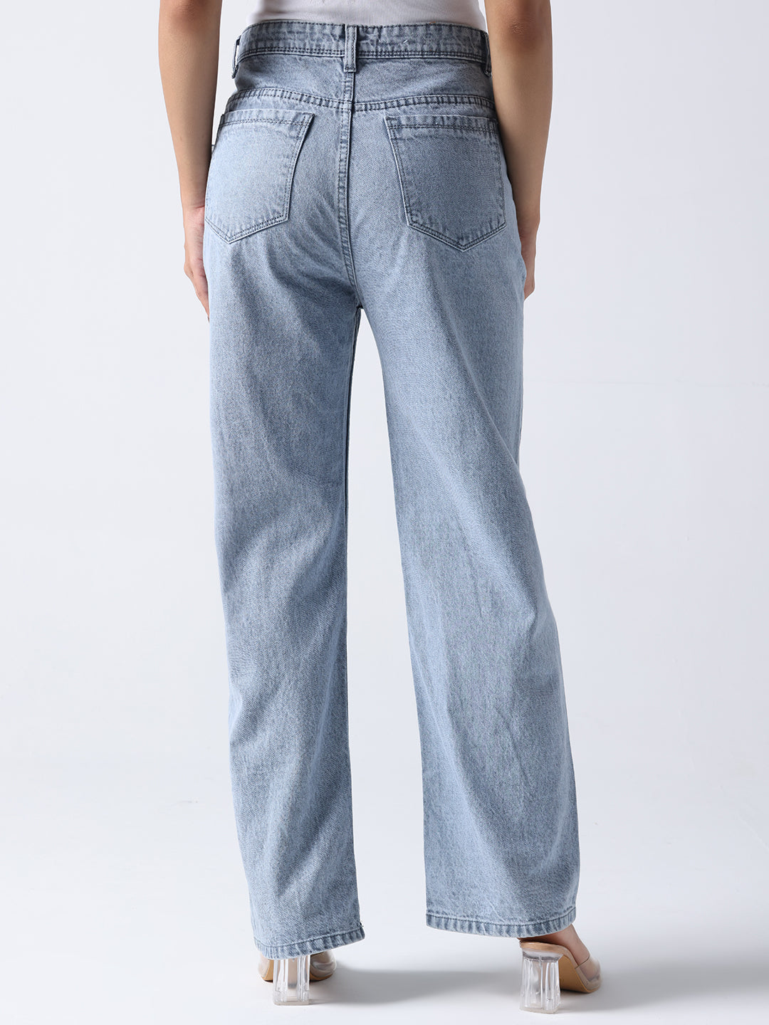 Back view of light blue jeans worn by model without visible brooch on jeans