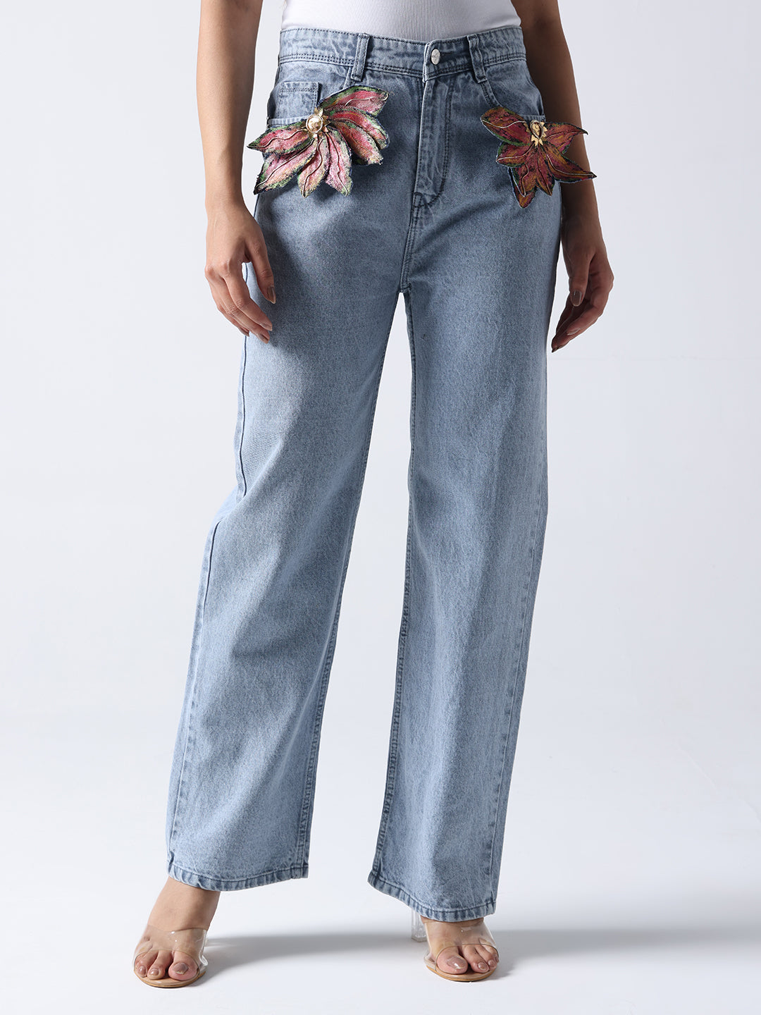 Light blue jeans with floral brooch on jeans detail near the pockets by Gotamoda