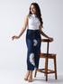 Woman wearing Daisy Dream Denim front cut Skirt with white daisy prints paired with sleeveless white top