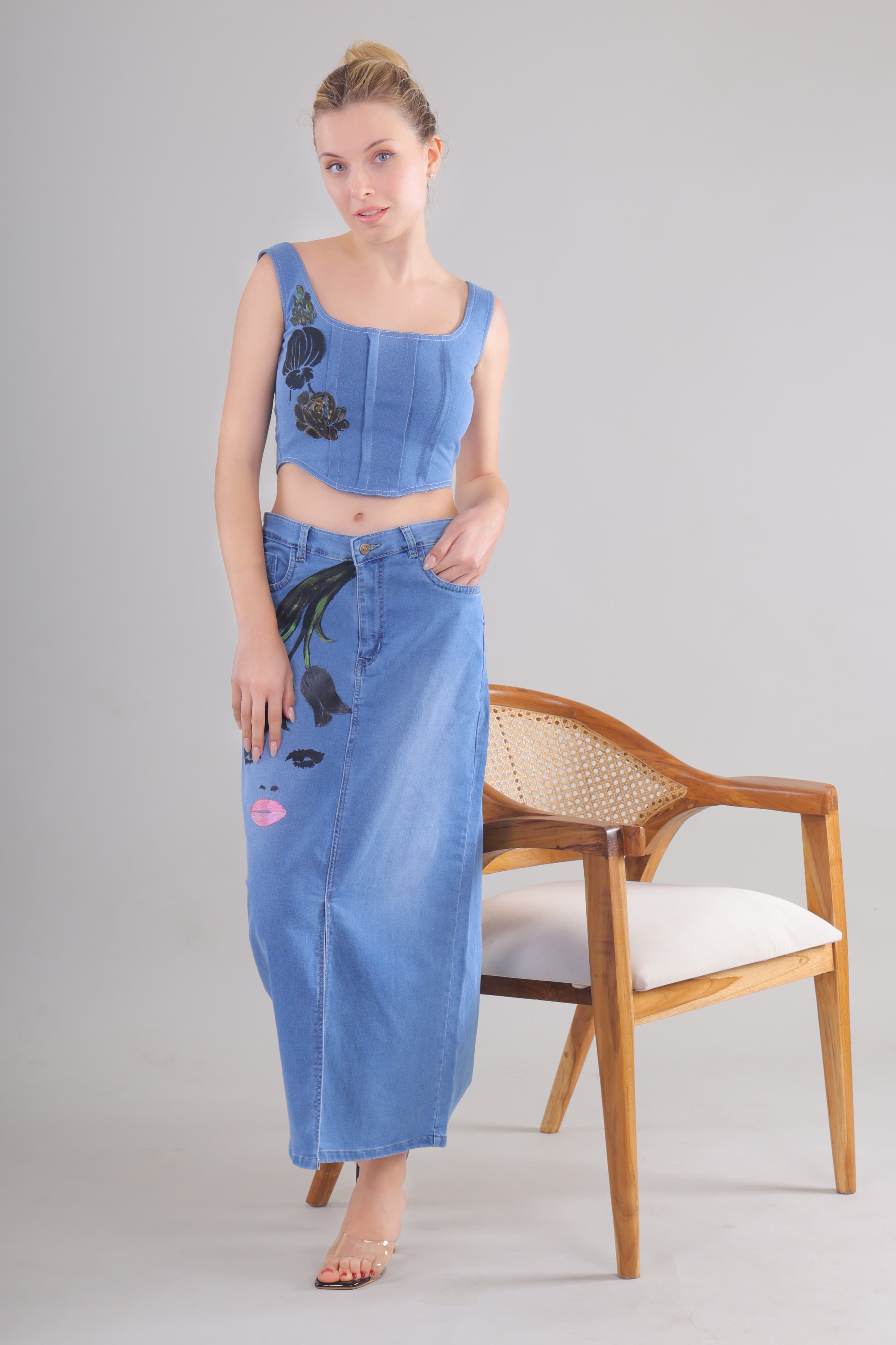Gotamoda denim corset co-ord set featuring a sleeveless cropped top and long denim skirt with floral and face print