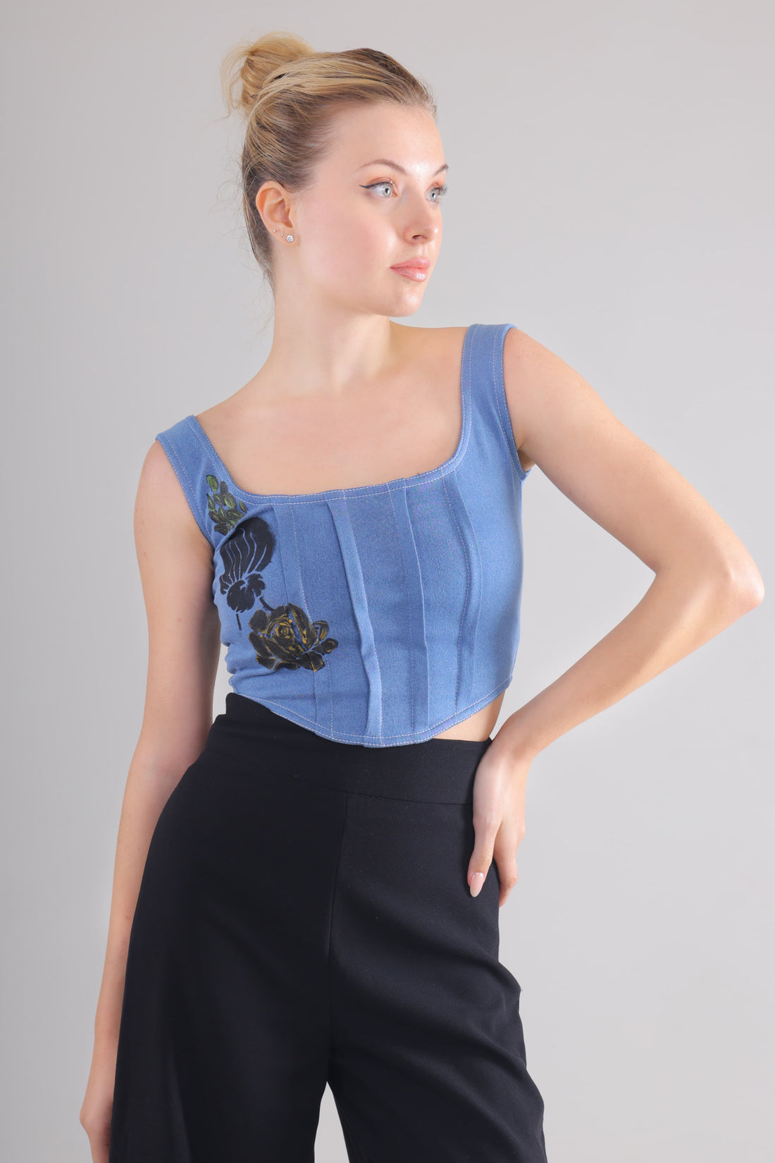 Gotamoda Denim Corset Top in blue with black floral embroidery worn with black pants