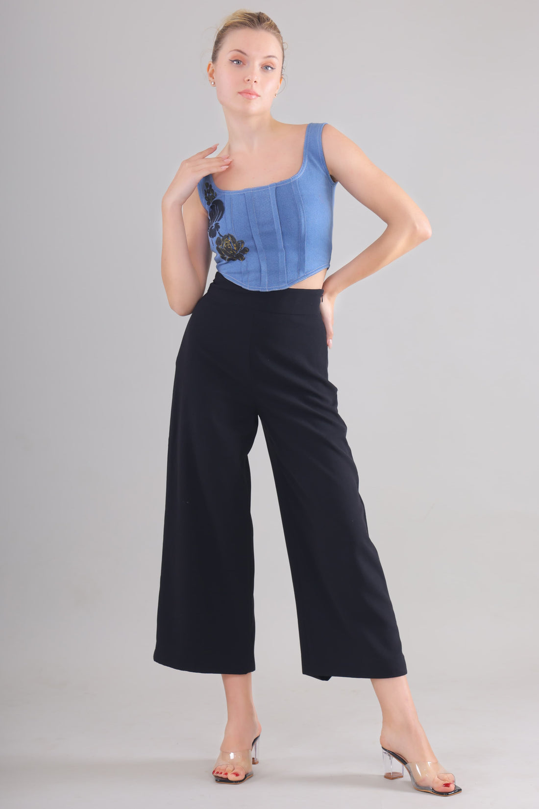Gotamoda Denim Corset Top in blue with floral embroidery paired with black wide-leg pants