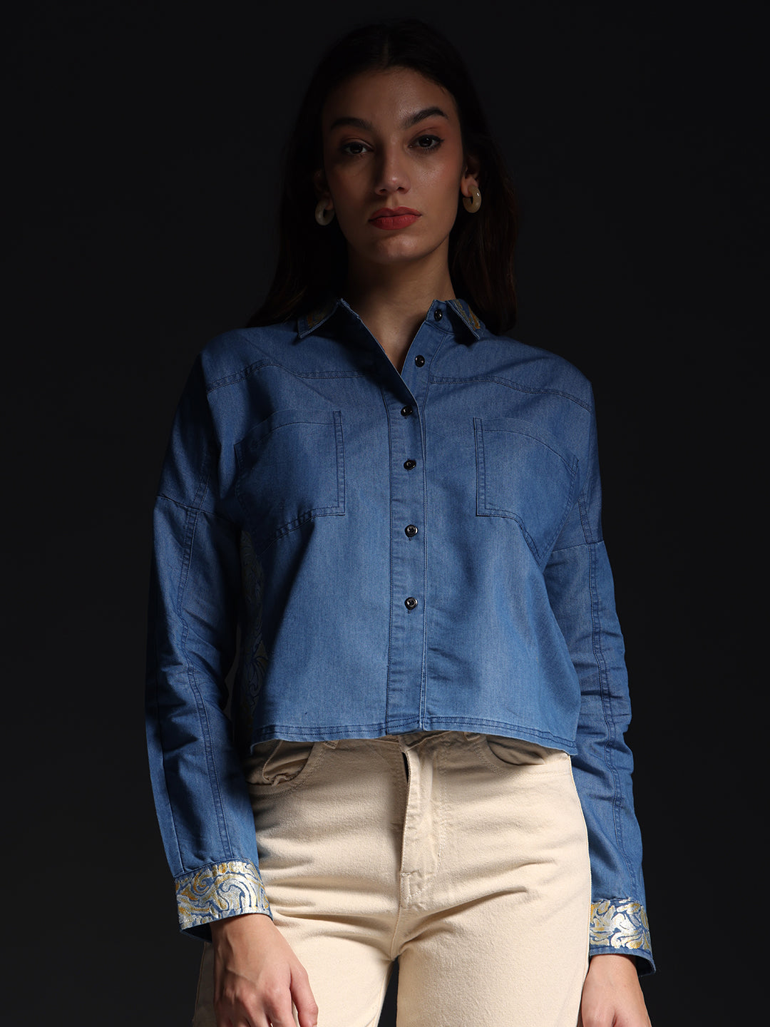 Gotamoda woman wearing denim shirt with white jeans against black background