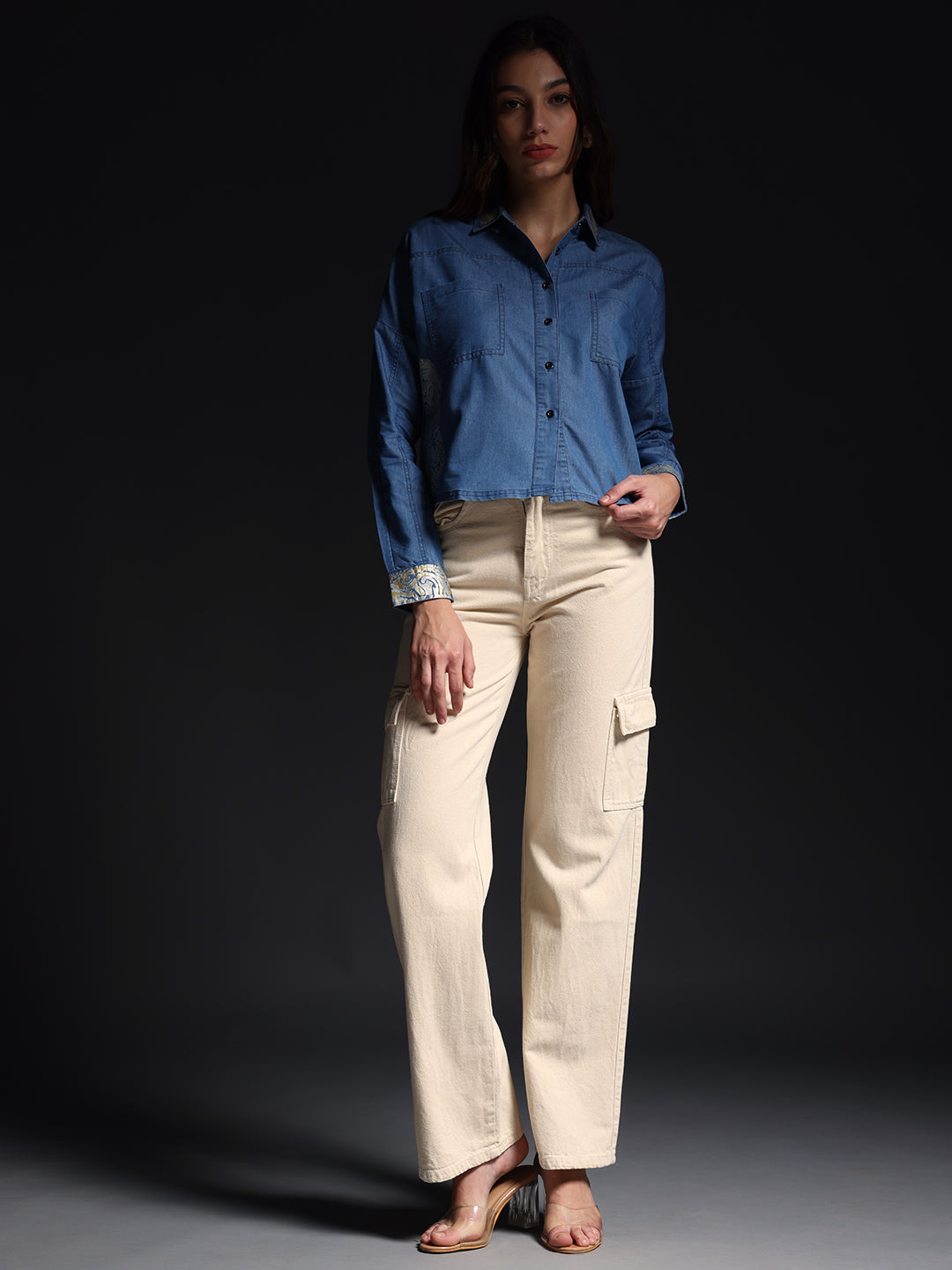 Model wearing denim shirt with white jeans styled with beige cargo pants and sandals