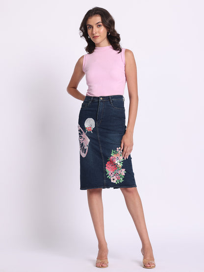 Gotamoda dark blue Denim Skirt with floral and butterfly embroidery worn by woman in pink sleeveless top