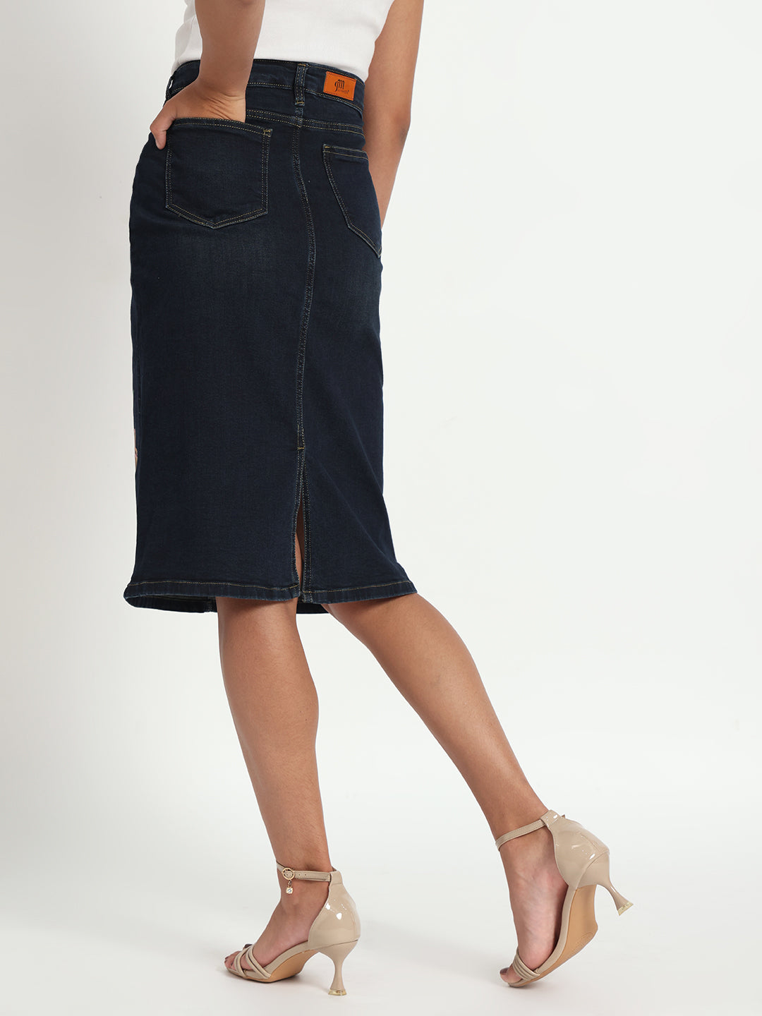Back view of hand-painted denim skirt by Gotamoda worn with beige heels and white top