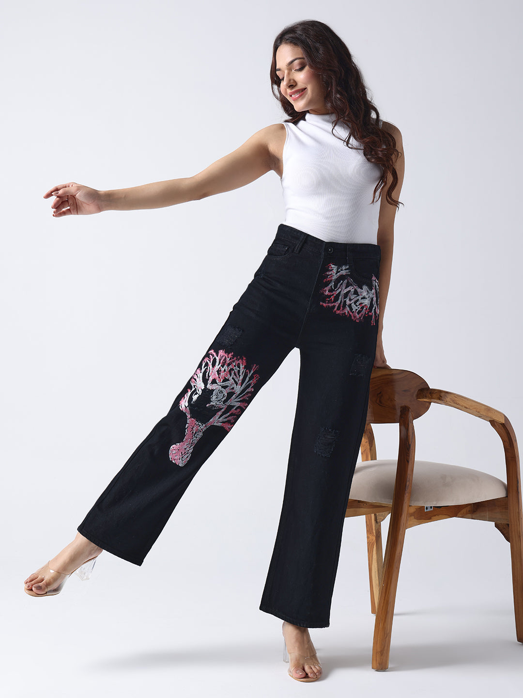 Gotamoda black hand painted jeans with artistic coral reef design worn by woman in white sleeveless top