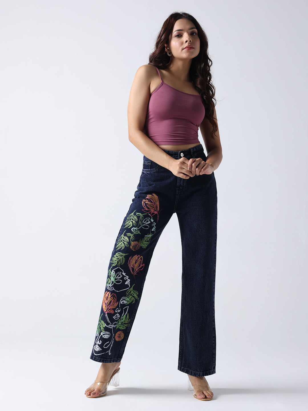 Gotamoda hand painted jeans with colorful floral designs worn by a woman in a purple tank top