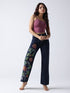 Gotamoda hand painted jeans with colorful floral designs worn by a woman in a purple tank top