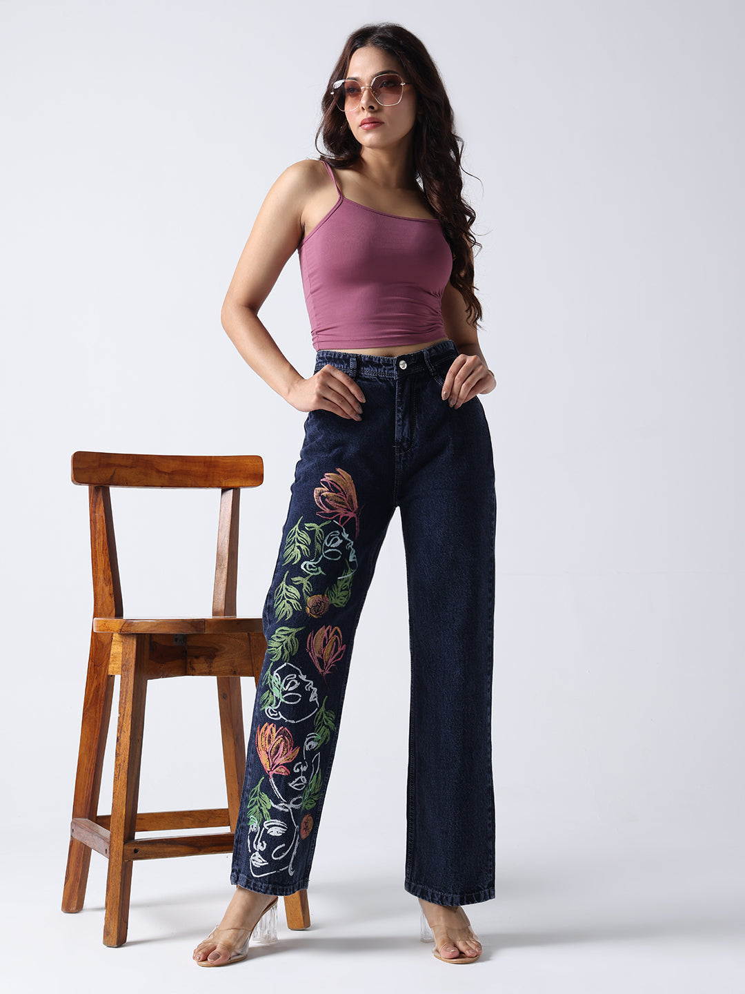 Gotamoda hand painted jeans with floral design worn by woman in purple tank top and sunglasses