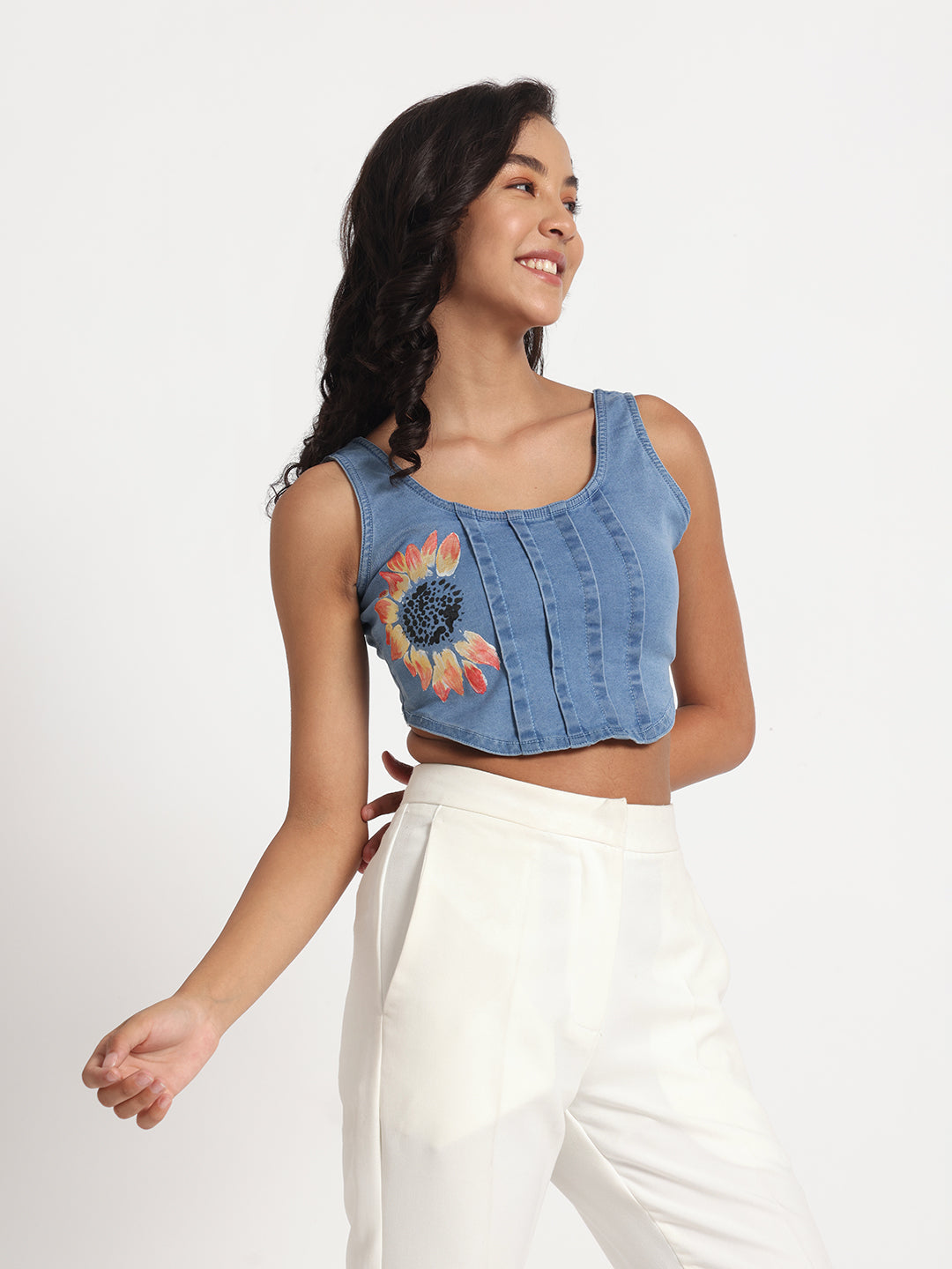 Gotamoda blue sleeveless jeans top with sunflower embroidery worn with white pants