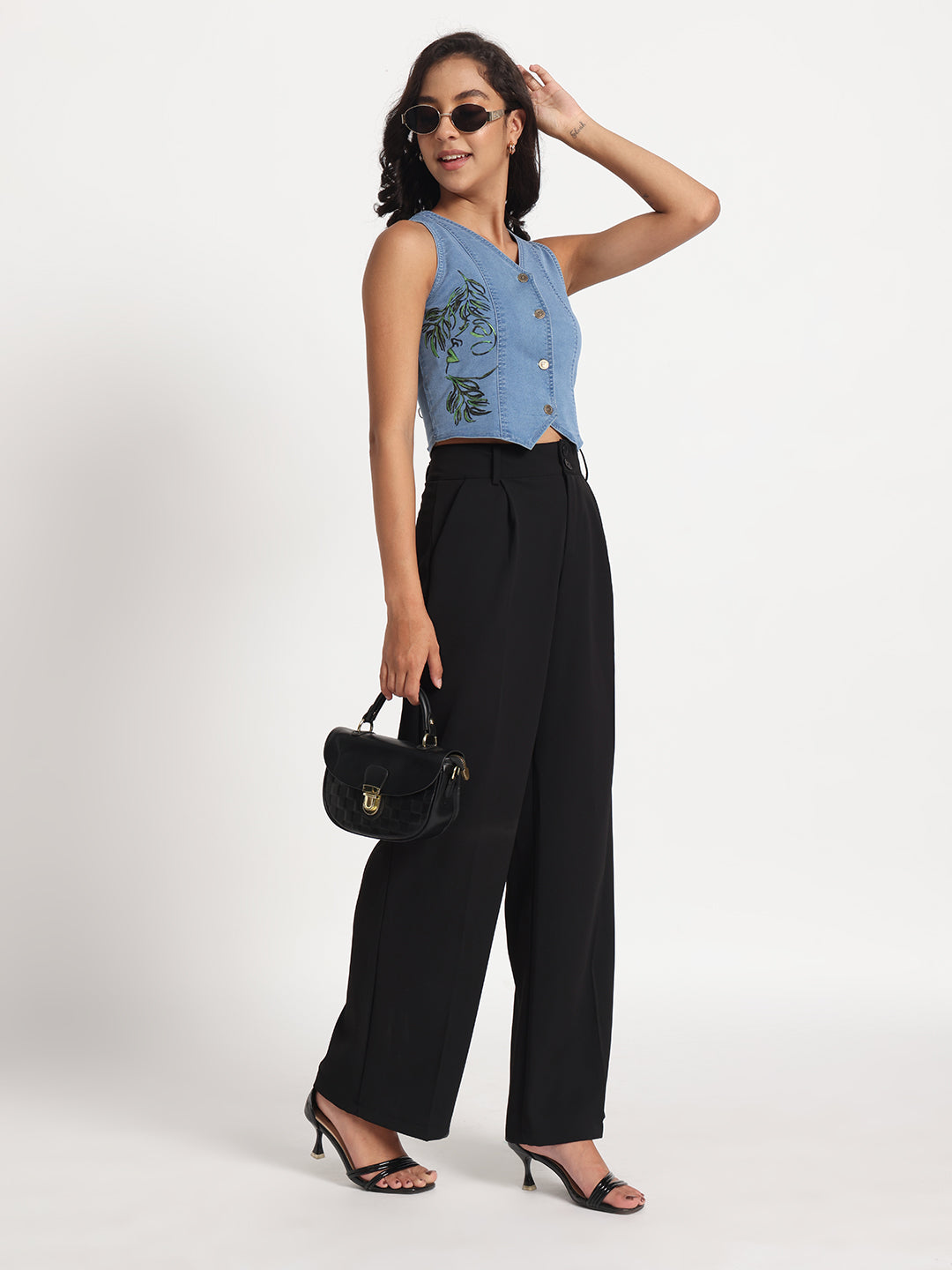 Woman wearing Gotamoda blue sleeveless Jeans Top with floral embroidery and black wide-leg pants