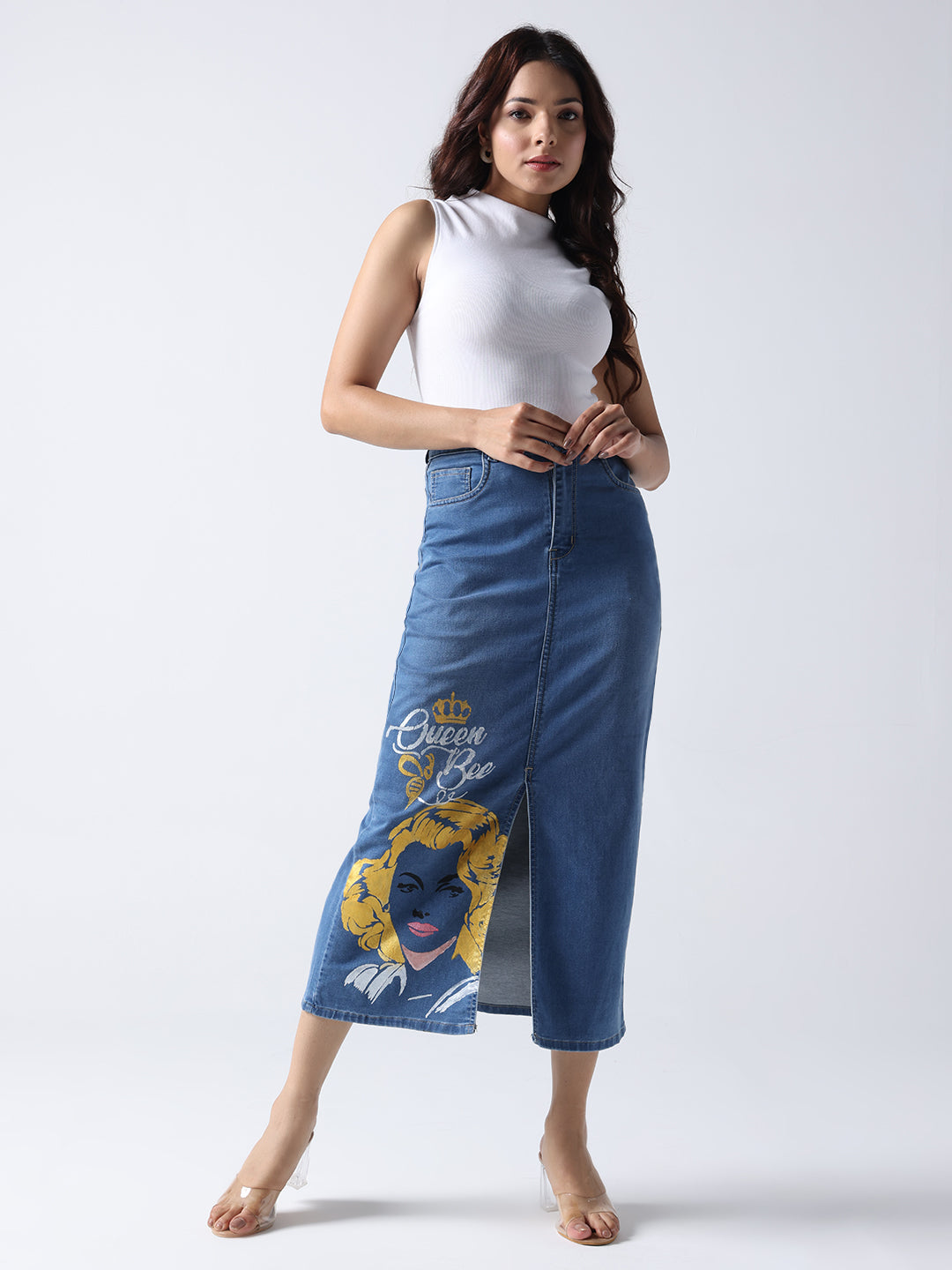 Woman wearing Gotamoda queen bee denim midi skirt with graphic print and front slit paired with white sleeveless top
