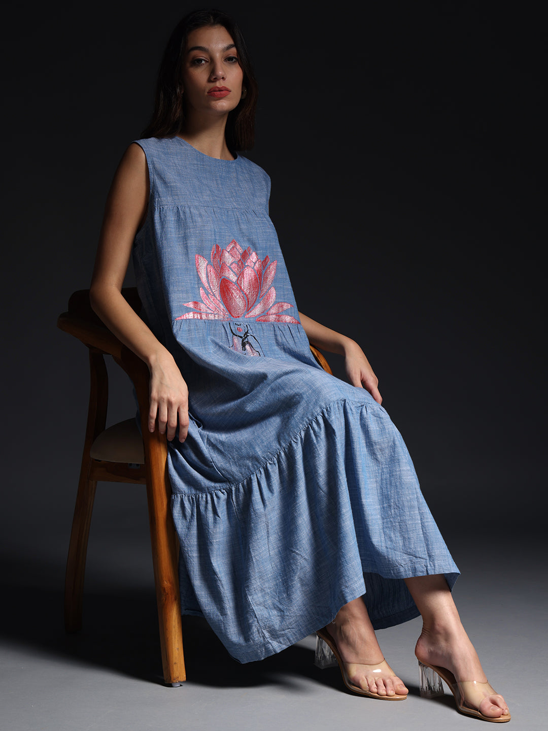 Gotamoda sleeveless maxi dress in blue with pink floral print worn by seated woman