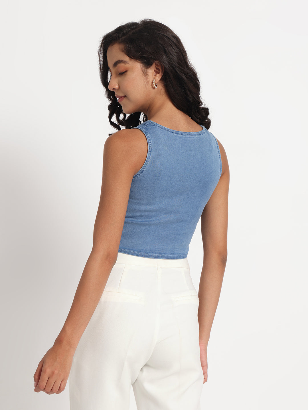 Gotamoda sleeveless top in jeans worn by woman paired with white pants from back view