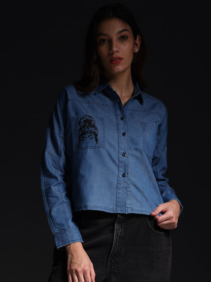Gotamoda top jeans shirt in blue denim with front pocket and long sleeves worn by a woman