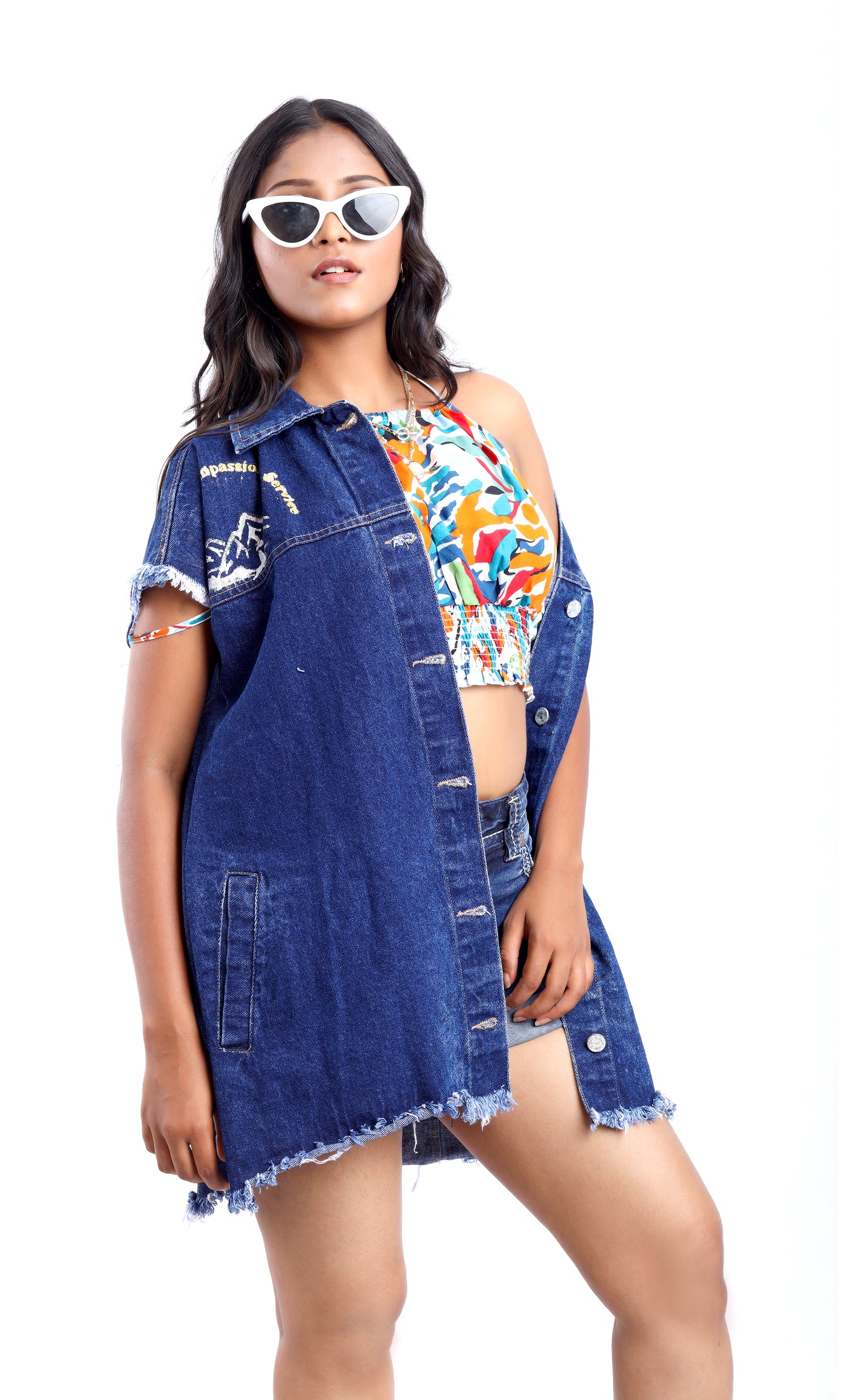Gotamoda sleeveless denim jacket in dark blue worn over colorful crop top and shorts