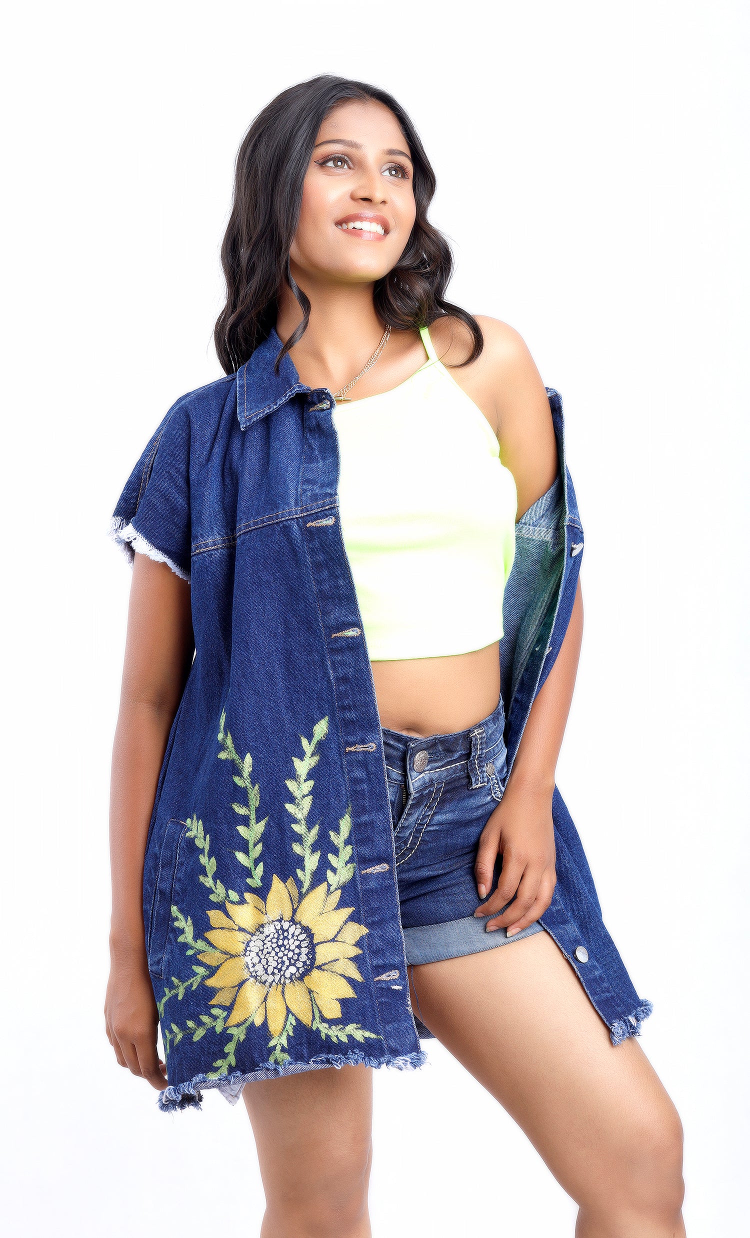 Gotamoda sleeveless denim jacket with sunflower embroidery worn over a white crop top and denim shorts