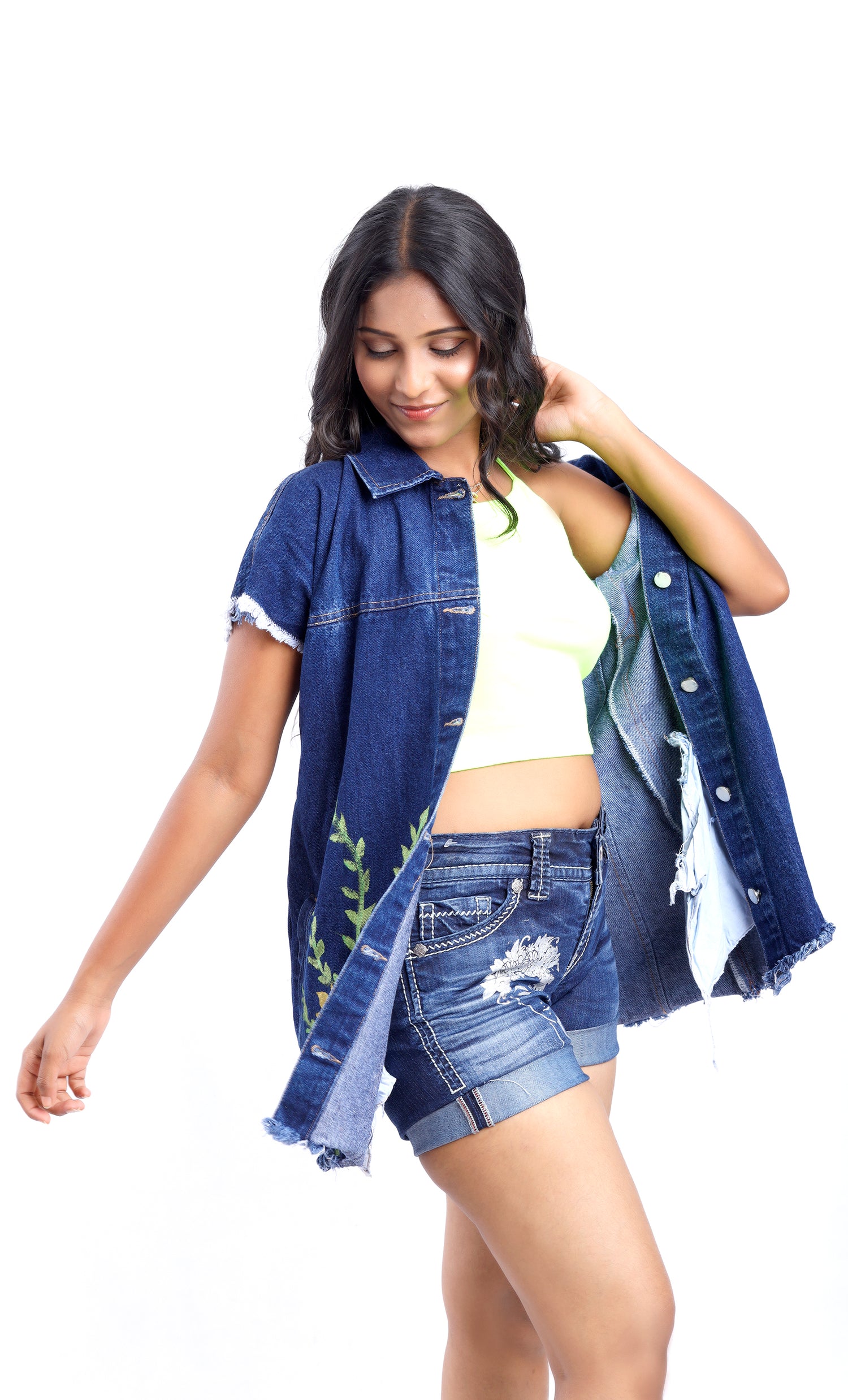 Gotamoda sleeveless denim jacket worn open by woman paired with ripped denim shorts